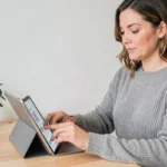 Femme utilisant une application de santé sur tablette dans un bureau minimaliste pour un bien-être optimal