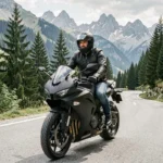 Motard en veste en cuir noir assis sur une moto sportive sur une route de montagne sinueuse dans les Alpes françaises